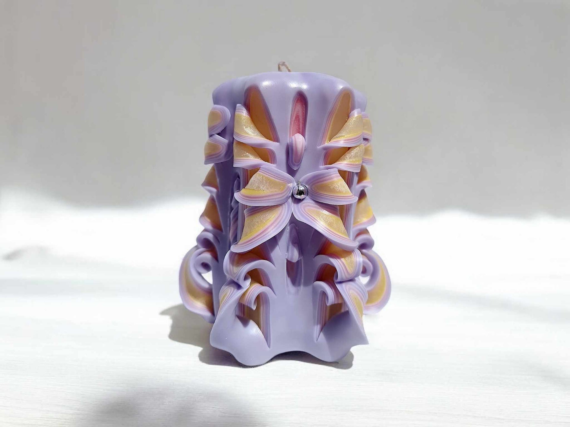 Handmade floral candle in purple with intricate design